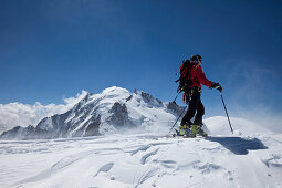 Ski mountaineer on Mont Blanc du Tacul, overlooking Mont Maudit and Mont Blanc, Chamonix-Mont-Blanc, France