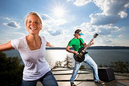 Girl and guitarist above Lake Starnberg, Upper Bavaria, Germany
