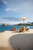 Paar sonnenbadend auf den Terrassen der Yachting Club Villas, Elounda Beach Resort, Elounda, Kreta, Griechenland