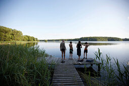 Familie auf einem Steg am Goldensee, Haus Strauss, Bauernkate in Klein Thurow, Roggendorf, Mecklenburg-Vorpommern, Deutschland