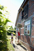 Vater mit Söhnen beim Heu einbringen, Haus Strauss, Bauernkate in Klein Thurow, Roggendorf, Mecklenburg-Vorpommern, Deutschland