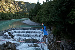 Junger Mann balanciert auf einer Highline über einen Fluss, Füssen, Bayern, Deutschland, Europa