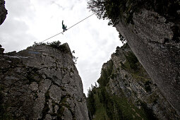 Young man balancing on a highline between two rocks, Oberammergau, Bavaria, Germany, Europe