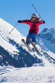 Ein Kind, ein Mädchen auf Ski springt über eine Schanze, Skigebiet Wiriehorn, Diemtigtal, Berner Oberland, Schweiz, Europa