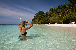 Woman snorkeling off the beach of Kurumba Island, North Male Atoll, Indian Ocean, Maldives