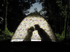 Silhouette of couple kissing in tent
