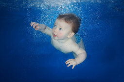 Small boy swimming underwater