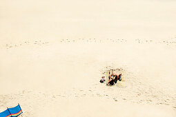 Couple sunbathing on white sandy beach. Couple sunbathing on white sandy beach