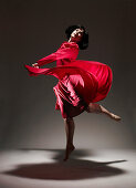 Woman in Red dress dancing under light