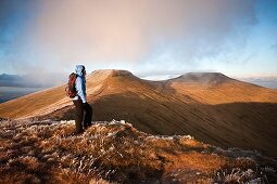 Female hiker with Corn Du and Pen Y Fan in Background, Brecon Beacons national park, Wales