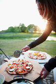 Frau schneidet Pizza, Haus Strauss, Bauernkate in Klein Thurow, Roggendorf, Mecklenburg-Vorpommern, Deutschland