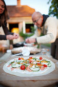 Mann und Frau beim Pizzabelegen im Garten, Haus Strauss, Bauernkate in Klein Thurow, Roggendorf, Mecklenburg-Vorpommern, Deutschland