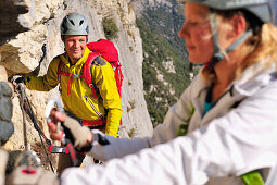 Junge Frau und junger Mann klettern am Klettersteig Rino Pisetta, Lago die Toblino, Sarche, Calavino, Trentino, Trentino-Südtirol, Italien