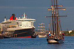 Sailing ship in front of cruise ship Queen Mary 2 at harbour, Hamburg Cruise Center Hafen City, Hamburg, Germany, Europe