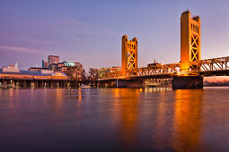 Tower Bridge over the Sacramento River, Sacramento, California, USA. Sunset over the city. Bridge with two tall towers. Downtown buildings. Reflections in the water., Tower Bridge over the Sacramento River