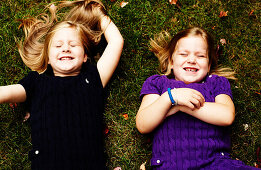 Two Young Girls Laying on Grass