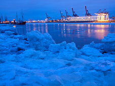 Eis am Ufer der Elbe am Abend, im Hintergrund der Containerhafen Waltershof, Hansestadt Hamburg, Deutschland, Europa