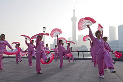 Morning exercises, women doing fan dance at the Bund in the morning, Shanghai, China
