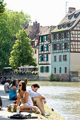 Junge Leute am Flußufer, Petite France, Straßburg, Elsass, Frankreich