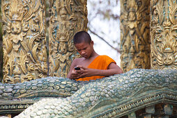 Junger buddhistischer Mönch mit Mobiltelefon in einem Tempel in der Provinz Kampot, Kambodscha, Asien