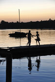 Paar tanzt auf einem Steg am Ammersee bei Sonnenuntergang, Herrsching, Oberbayern, Bayern, Deutschland, Europa