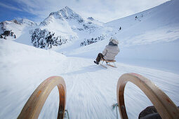 Couple sledding downhill, Kuehtai, Tyrol, Austria