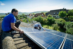 Two persons installing a solar plant, Freiburg im Breisgau, Black Forest, Baden-Wuerttemberg, Germany, Europe