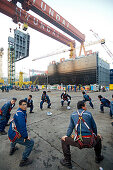 Shipyard workers doing morning exercises before shift, modular production at the largest shipyard in the world Hyundai Heavy Industries, HHI, in Ulsan, South Korea, Asia
