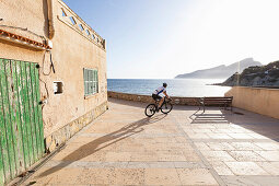 Bicycle rider at the Mediterranean coast, Sant Elm, Majorca, Balearic Islands, Spain