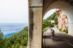 Rennradfahrer in Küstenstraßen-Tunnel am Mittelmeer, Estellencs, Mallorca, Spanien
