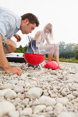 Young couple on the Isar riverbank, Munich, Bavaria, Germany