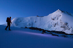 A man hiking with head torch, ascent at dawn to the summit of Mount Wildi Frau, view to Blueemlisalp mountains, Morgenhorn, Wyssi Frau, Bernese Oberland, Canton of Bern, Switzerland