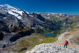 A man hiking, view to Doldenhorn, Oeschinensee, Kandersteg, Kandertal from ridge between Schwarzhorn and Bundstock, Bernese Oberland, Canton of Bern, Switzerland