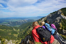 Young woman and two young men enjoying the view from Aggenstein to Fuessen, Aggenstein, Tannheim range, Tyrol, Austria