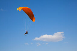 Paraglider in front of clouded sky