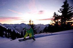 Snowboarder making a turn in fresh snow, Hahnenkamm, Tyrol, Austria
