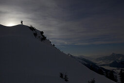 Snowboarder steht auf Berggipfel, Hahnenkamm, Tirol, Österreich