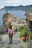 Woman walking on a path towards Vernazza, Mediterranean sea in the background, Vernazza, Cinque Terre, National Park Cinque Terre, UNESCO World Heritage Site Cinque Terre, Liguria, Italy