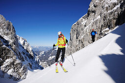 Man and woman downhill skiing from Rote-Rinn-Scharte to cirque Hoher Winkel, Kaiser-Express, Wilder Kaiser, Kaiser mountain range, Tyrol, Austria