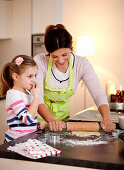 Mother and daughter (4 years) baking cookies