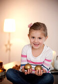 Girl (4 years) holding christmas tree balls