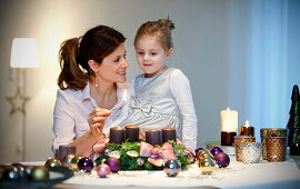 Mother and daughter  lighting candle on an Advent wreath, Styria, Austria