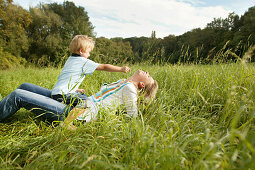 Mutter und Sohn (3 Jahre) spielen im Gras, Wien, Österreich