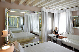 Woman using a laptop in hotel suite, Venice, Veneto, Italy