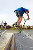 Teenager with city scooter in Skate park, Leioa, Bizkaia, Basque Country, Spain