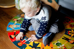 Junge (2 Jahre) puzzelt auf einem Tisch, Hinterjetzbachtal, bei Maria Alm, Pinzgau, Salzburger Land, Österreich