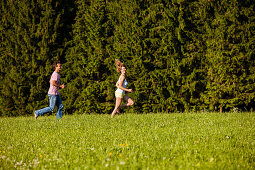 Paar läuft über eine Wiese, Oberbayern, Deutschland