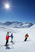 Three skiers on slope, Zurs, Lech, Vorarlberg, Austria