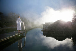 Woman on a jetty at a natural source pond, Tannheim, Tannheim Valley, Tyrol, Austria