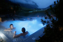 Hotel guests bathing in an outdoor saltwater bath, Tannheim, Tannheim Valley, Tyrol, Austria